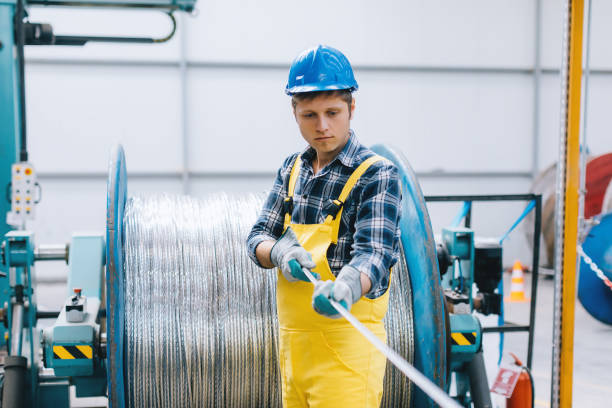 Portrait of young businessman working with cable roll in factory