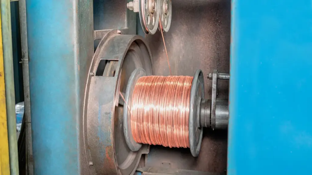 Copper wire spooling onto rotating reel during automated manufacturing process