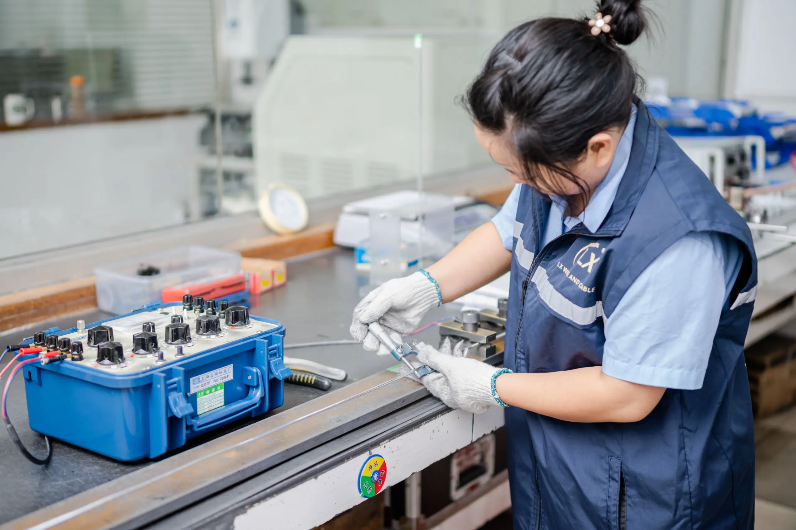Female technician testing electrical equipment in a laboratory