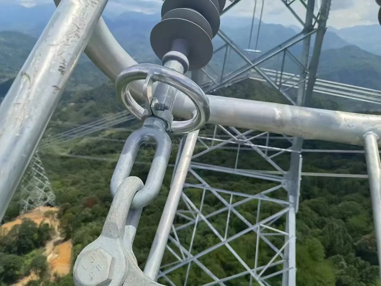 Close-up of galvanized tension clamps and polymer insulators for power lines