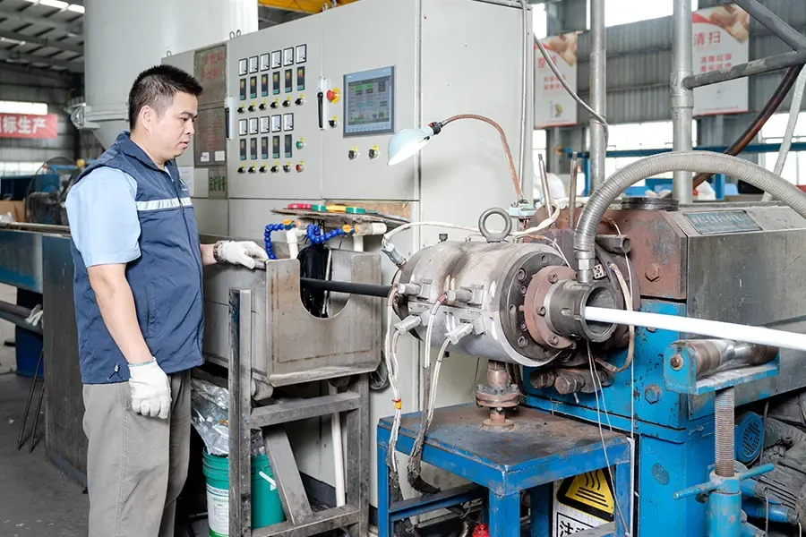Worker operating an inner sheathing extrusion machine